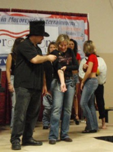 Pam on stage showing her ink to the MC